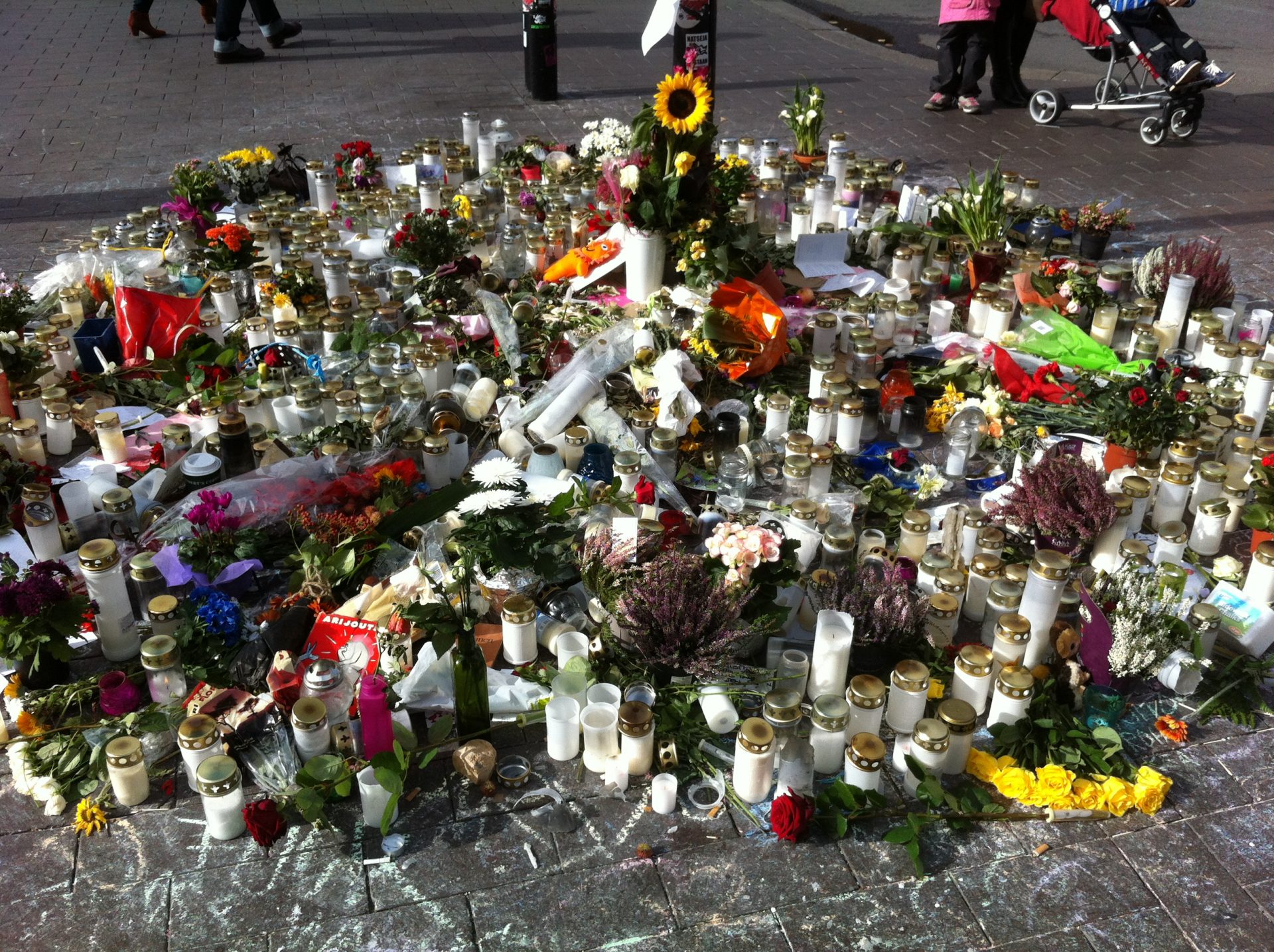 Flowers and candles placed on the ground.