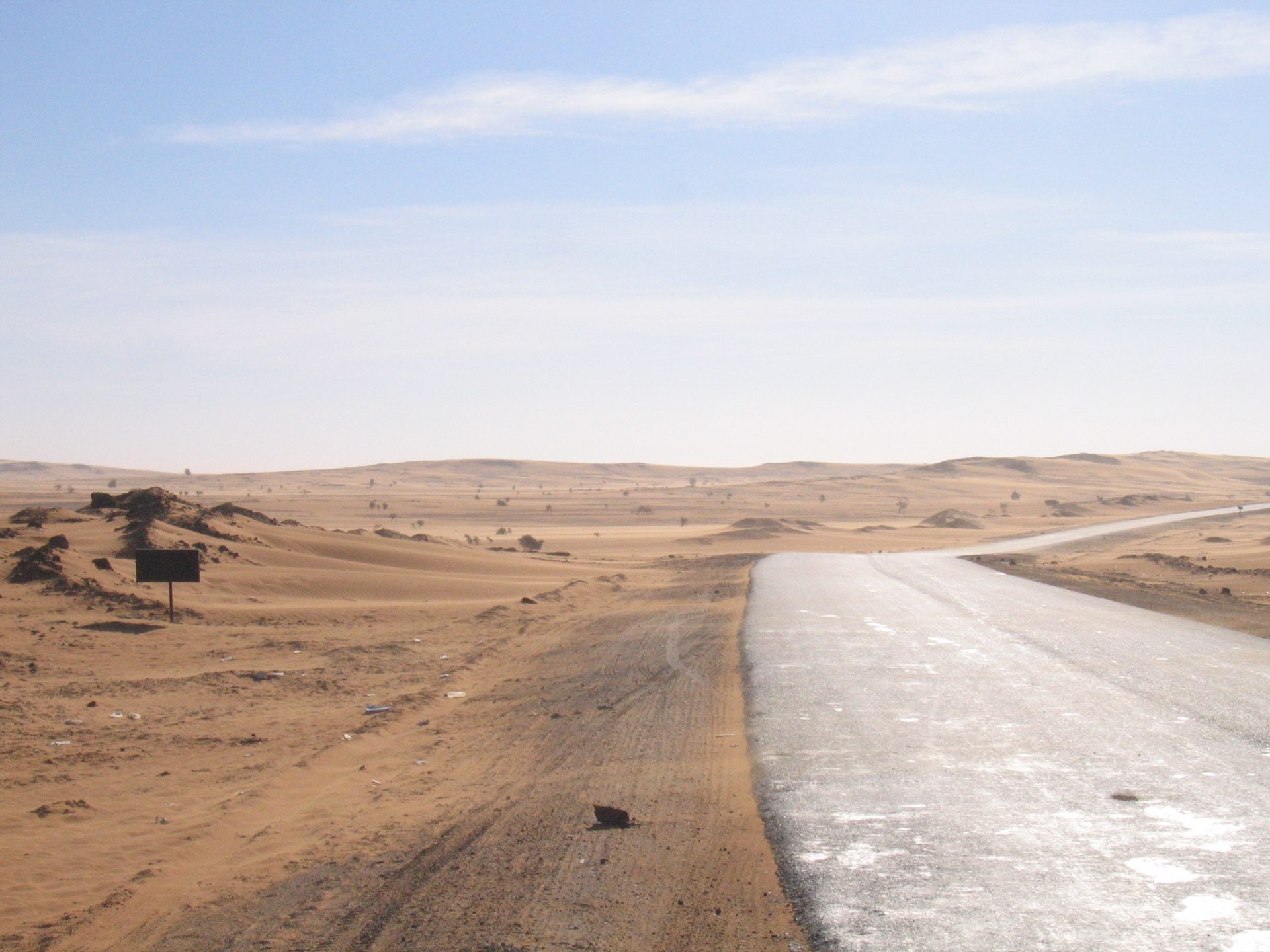 Tarmac road crossing a sunlit desert.